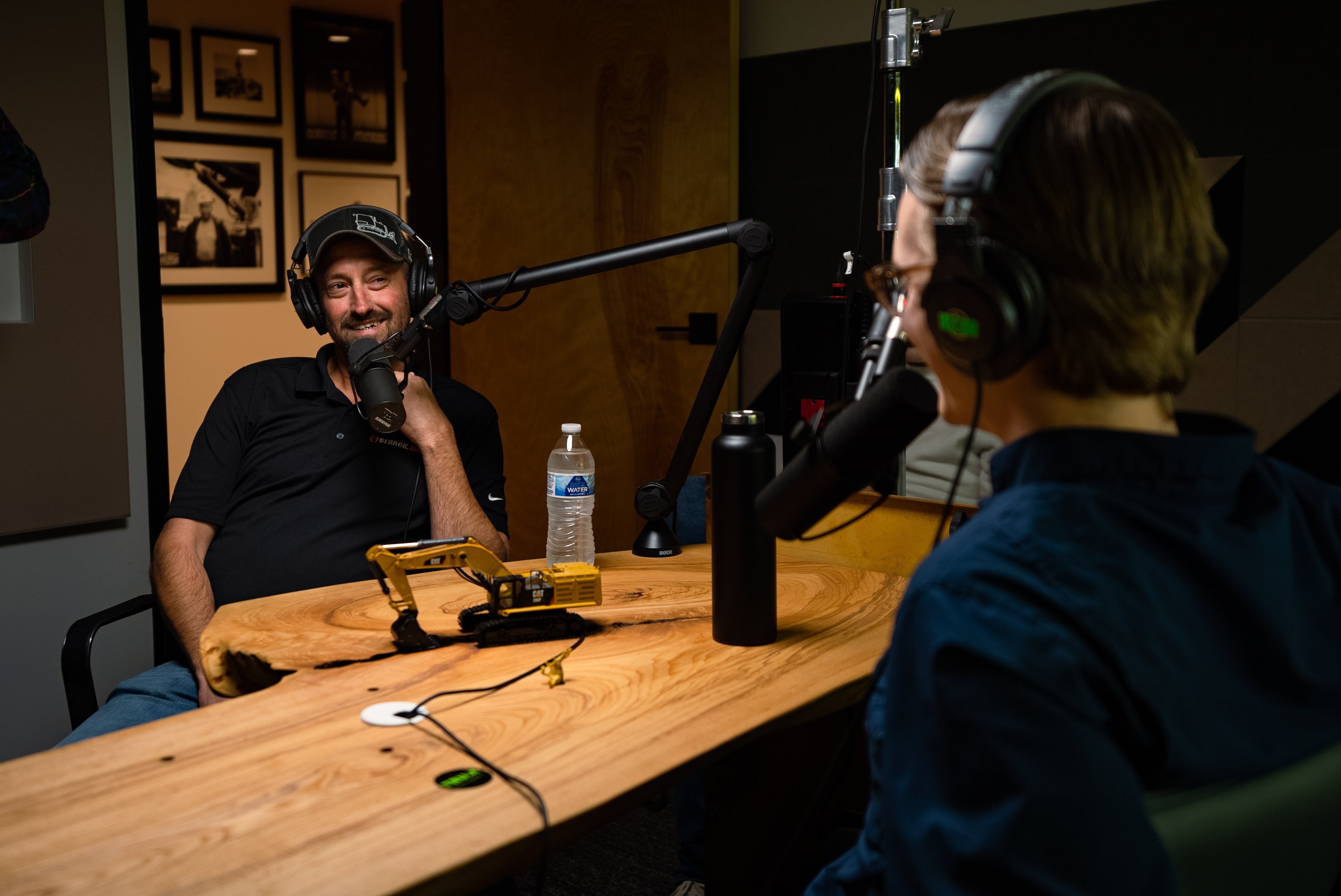 Aron Nick sits in front of a microphone while talking to Aaron