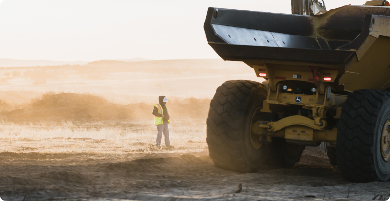 Person standing by large haul truck